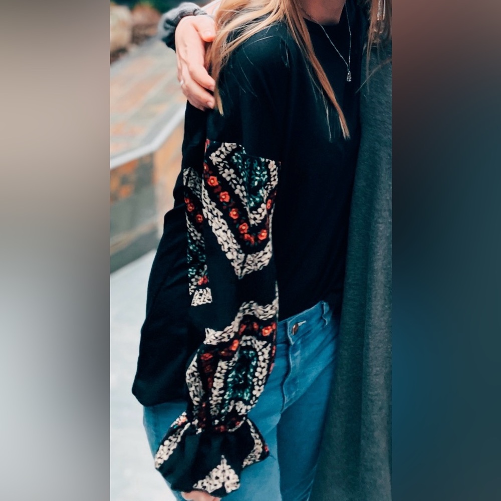 Black shirt with long, patterned sleeves. Women’s size L